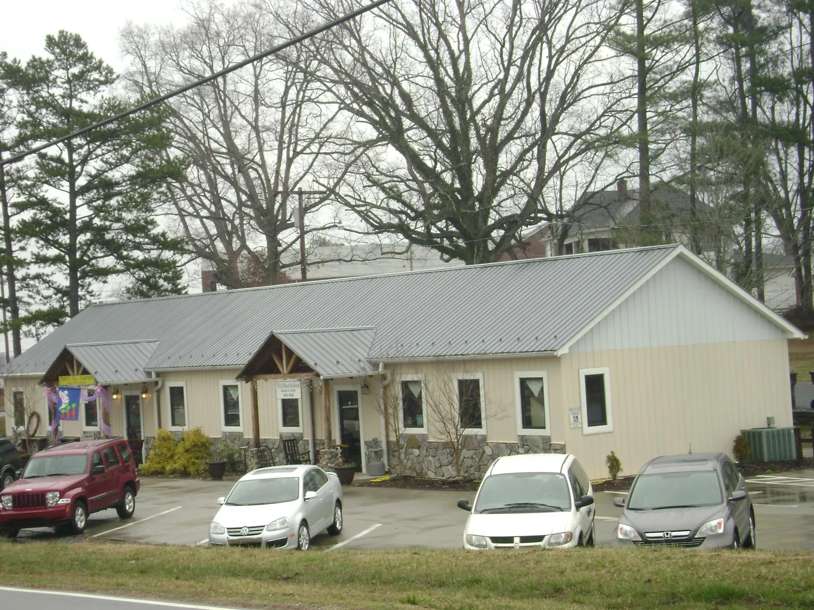 Gray metal roof with timber entry brackets on a small commercial building in Destin