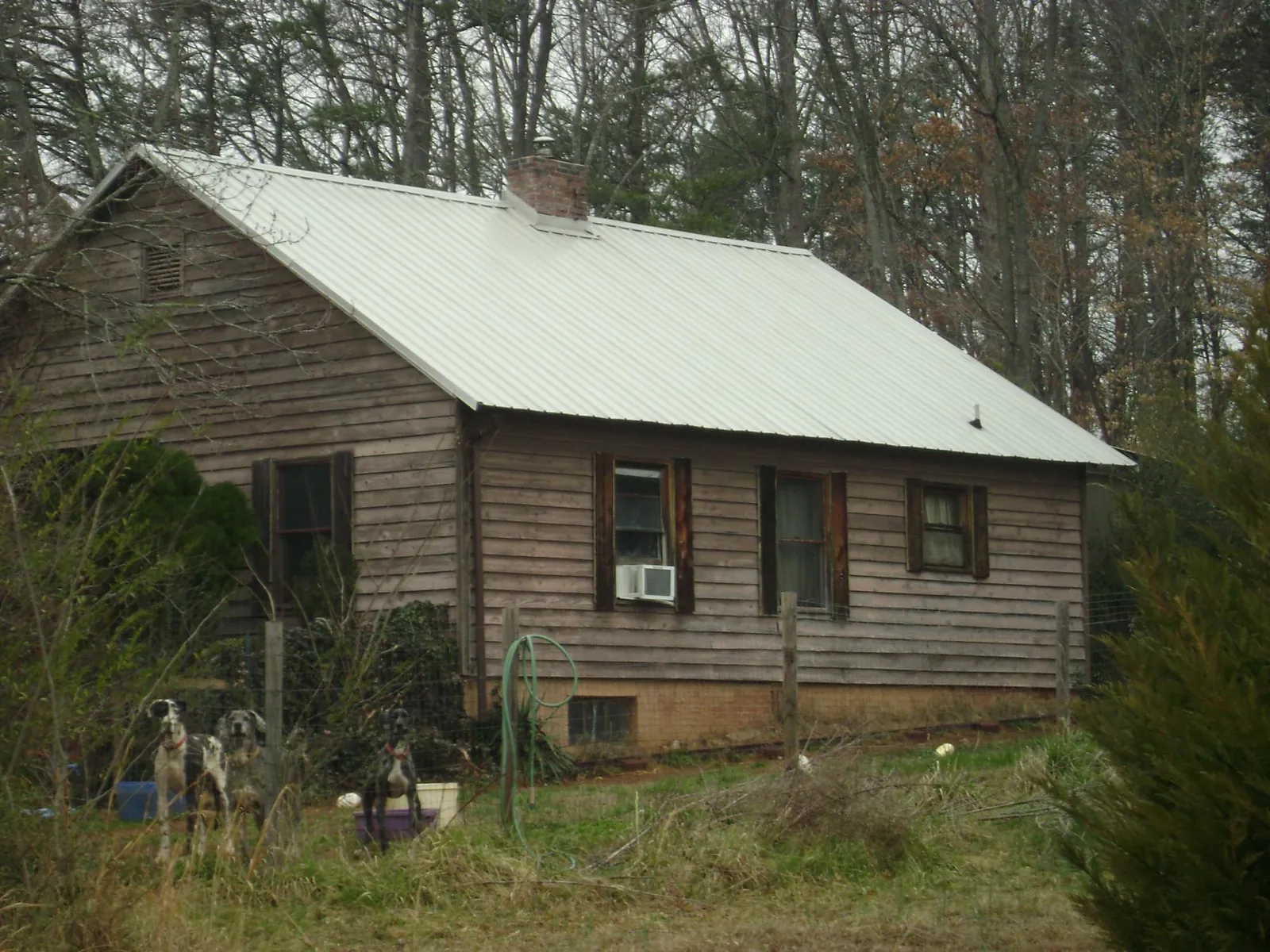 White metal roof on an old wood sided farmhouse, from a Asphalt Shingle Roof Repair job in Destin